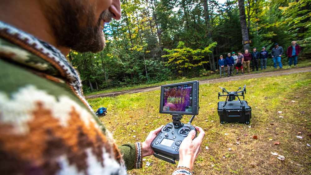 Dan Hayes takes his forestry class out into the Demeritt Forest to conduct a drone demo.